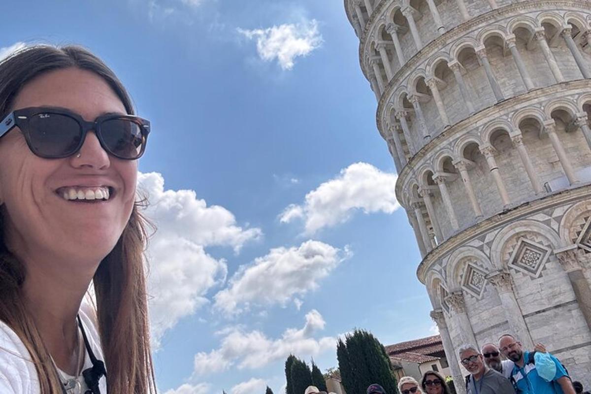 žena se slunečními brýlemi stojící před šikmou věží