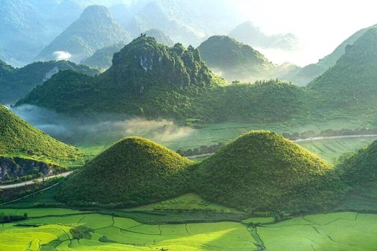 a painting of a mountain valley with green hills