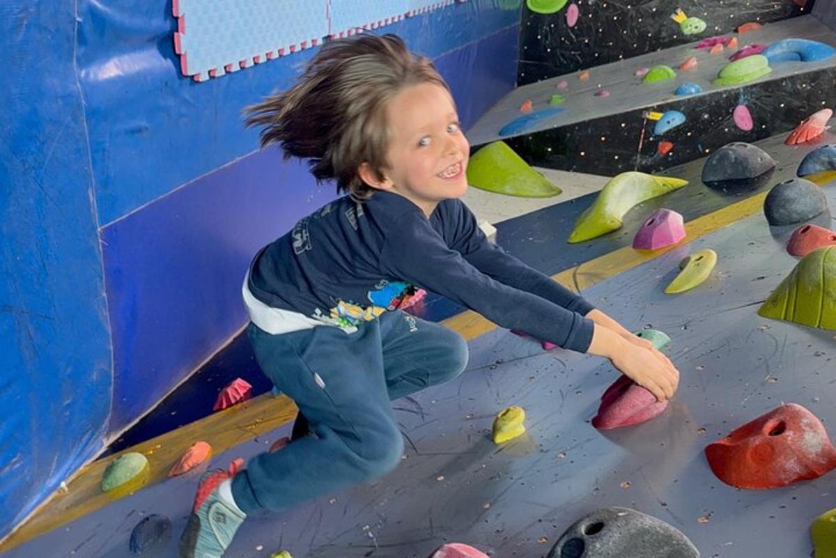 un jeune garçon jouant dans une salle d'escalade