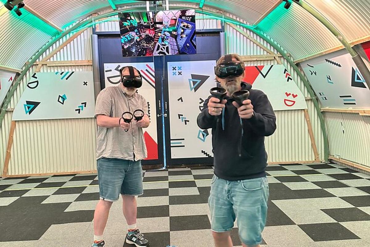 dva muži stojící v místnosti a fotící fotoaparáty