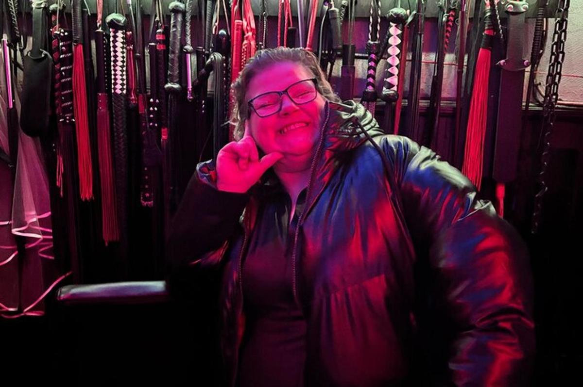 a woman talking on a cell phone in a rack of umbrellas