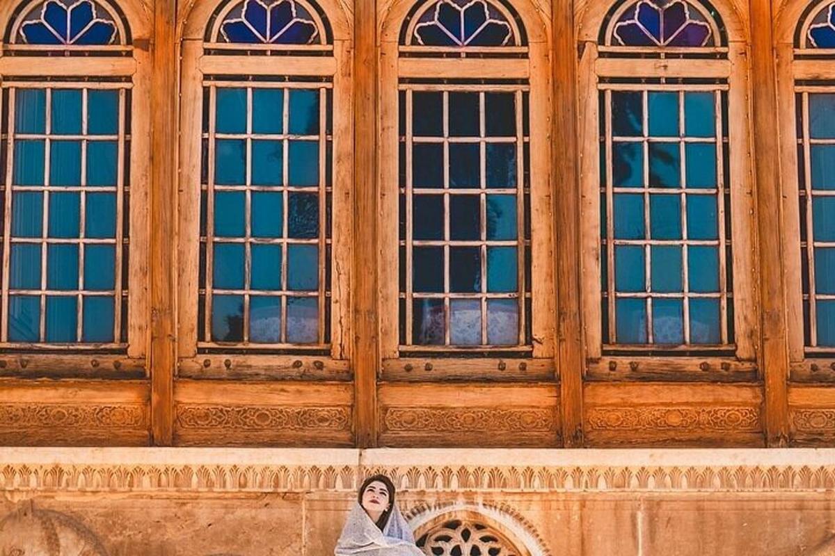 a woman sitting in front of a building with windows