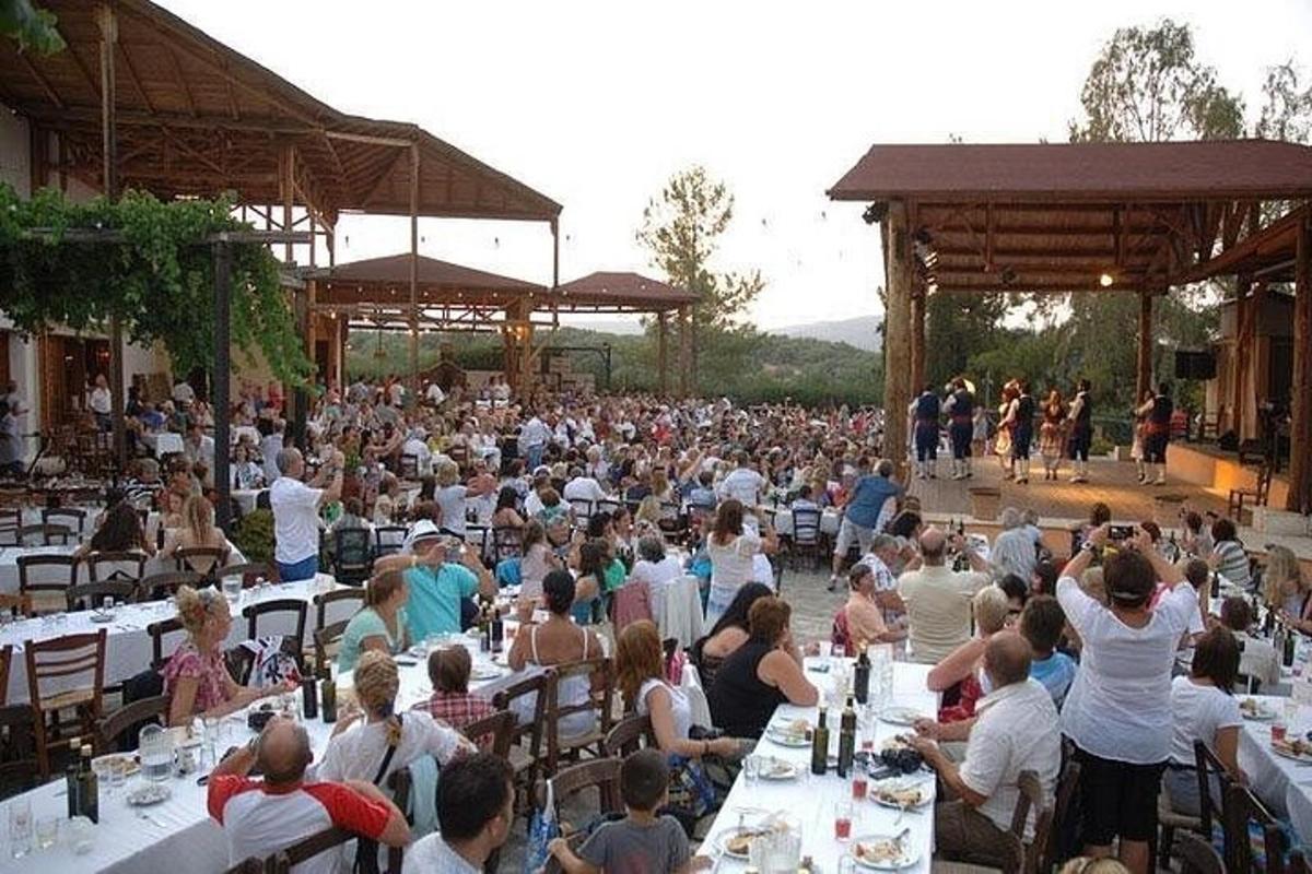 una grande folla di persone sedute ai tavoli durante un concerto