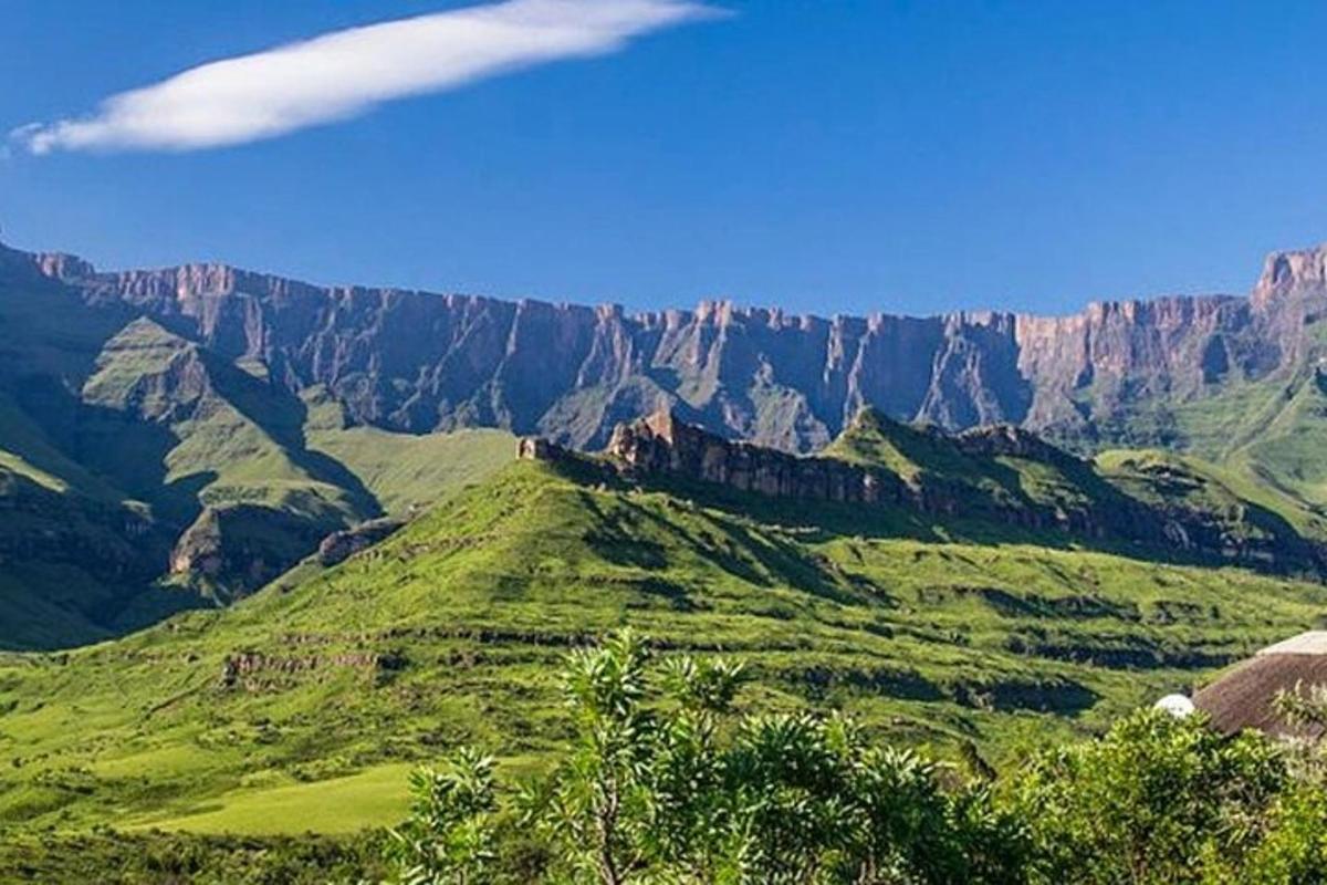 uma vista de uma montanha com grama verde e penhascos