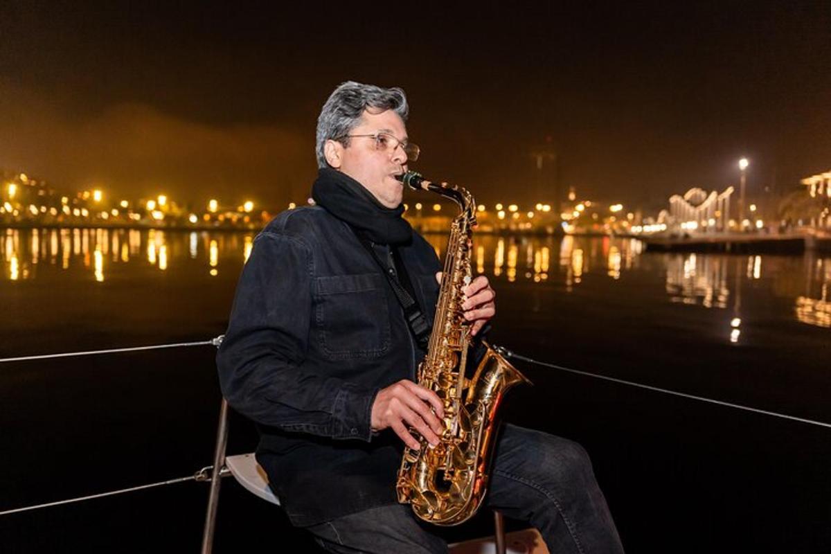 maður situr á báti og spilar á saxófón