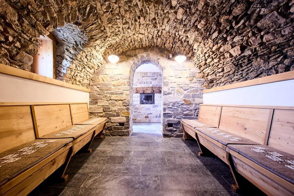 una stanza con panche di legno in un muro di pietra