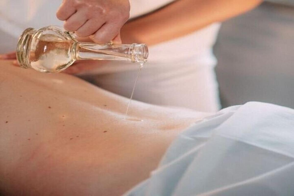 a woman is washing her buttocks with a glass bottle