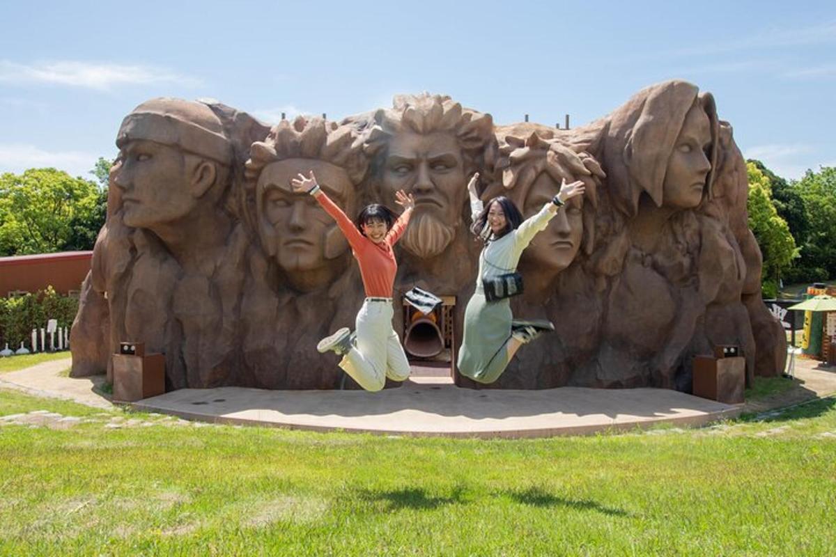 two people jumping in front of a statue of faces