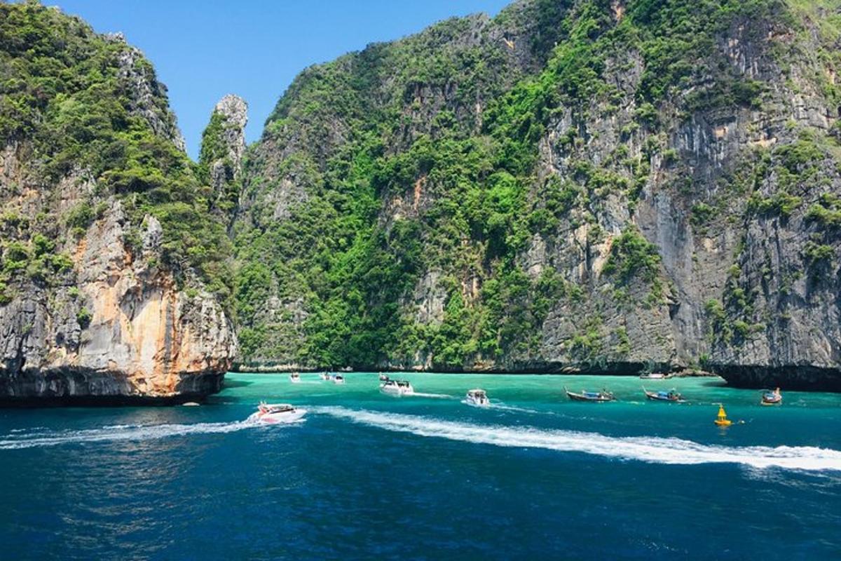 un groupe de bateaux dans l'eau près des falaises