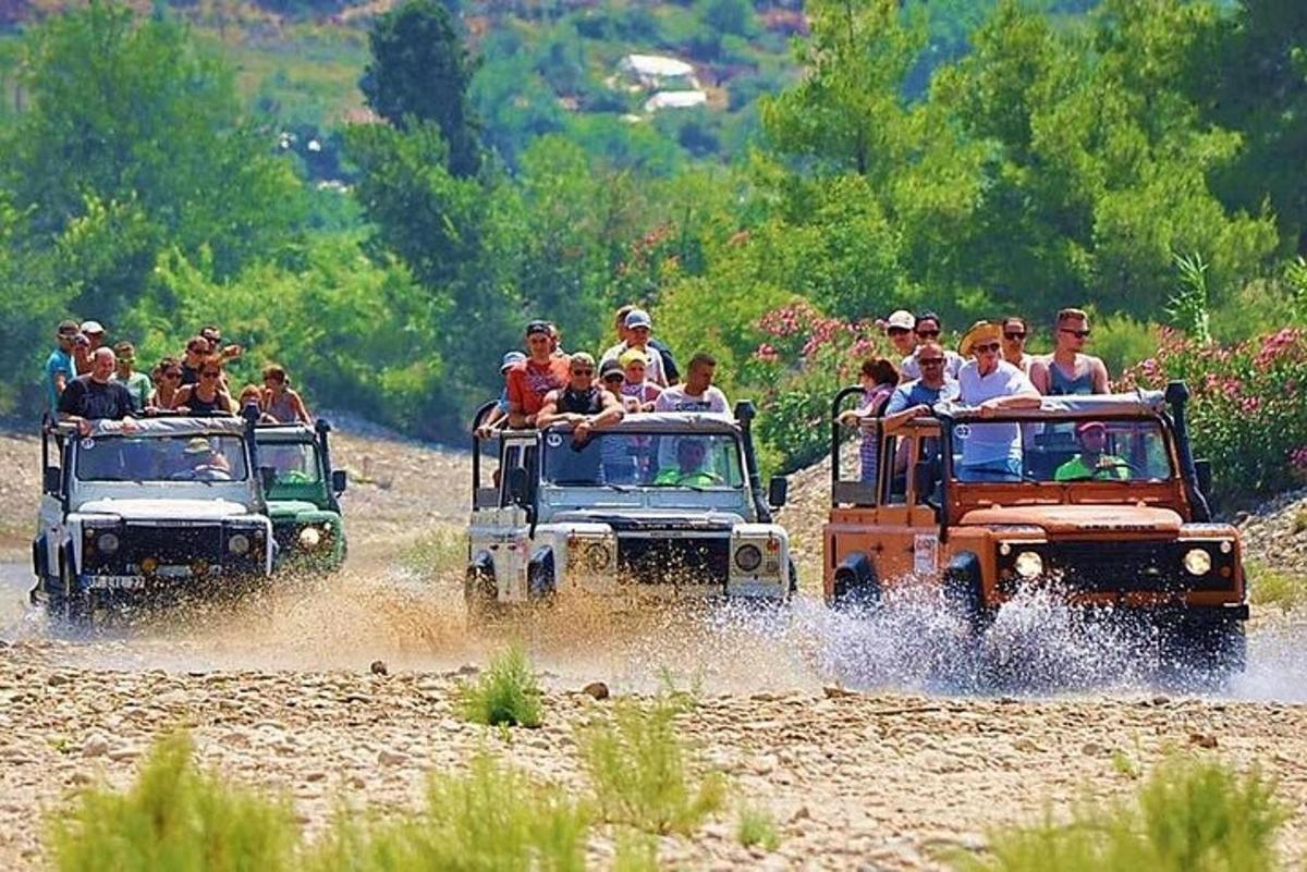 μια ομάδα ανθρώπων που οδηγούν τζιπ σε έναν χωματόδρομο