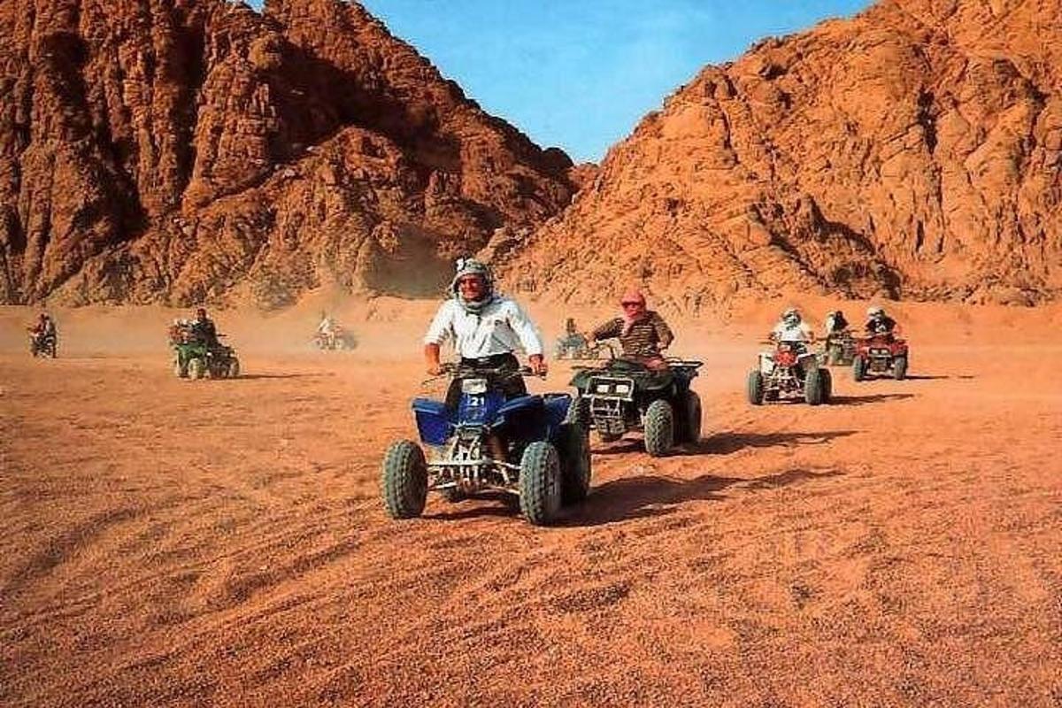un gruppo di persone in sella a quad nel deserto