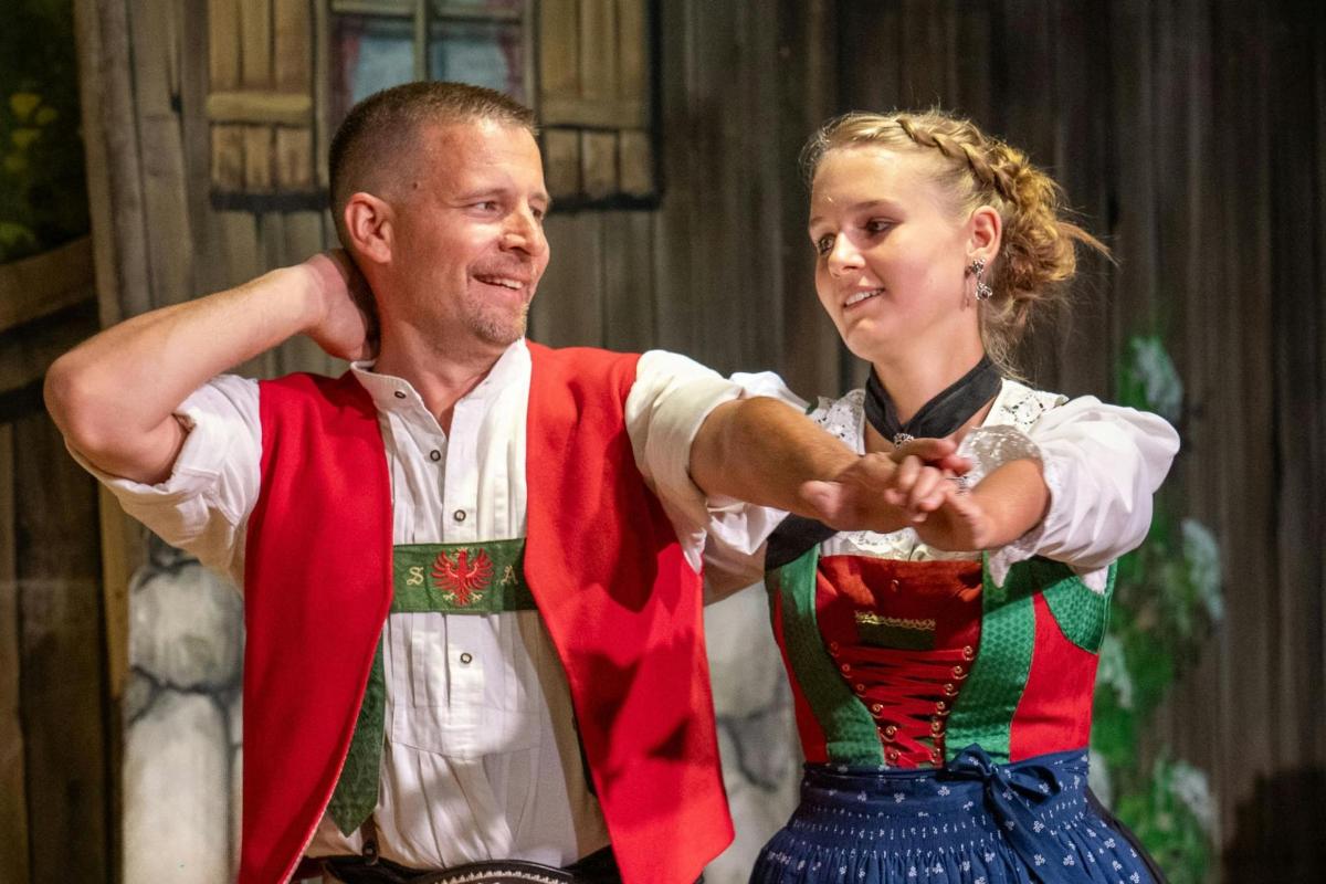 a man and a woman in traditional dances on a stage