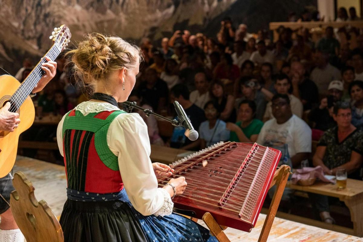 a woman playing an accordion in front of a crowd