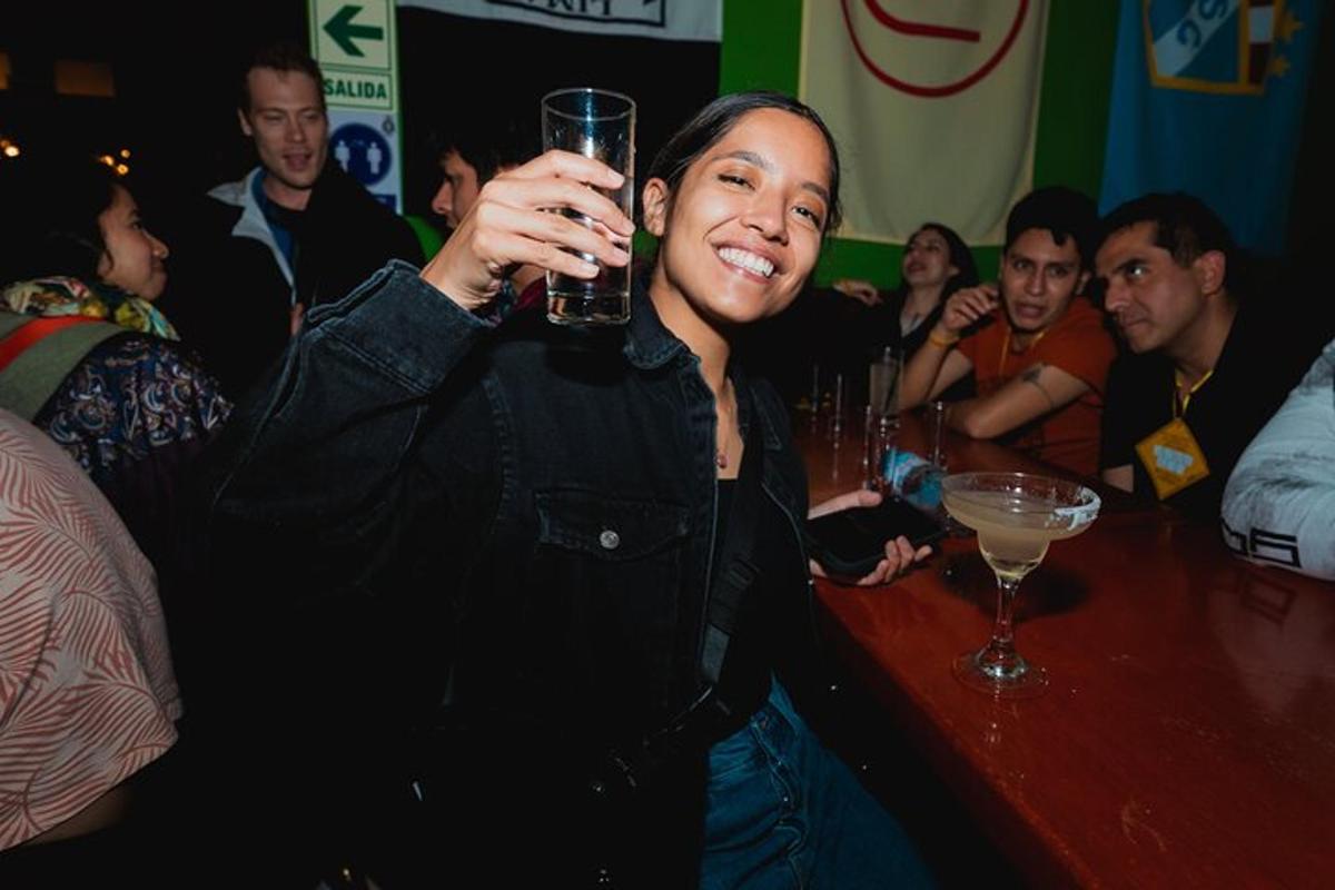 seorang wanita memegang gelas di bar