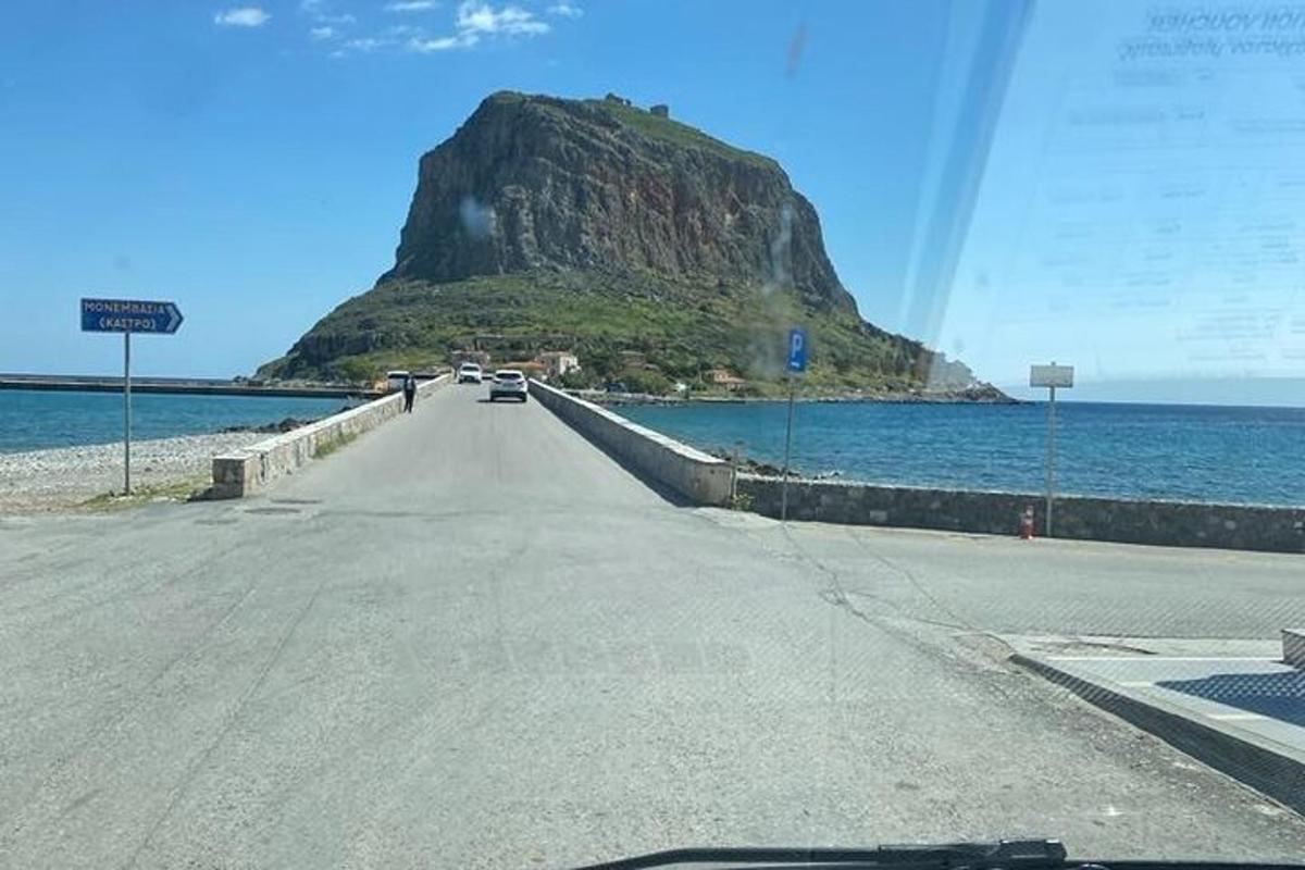 una strada con una montagna in mezzo all'oceano