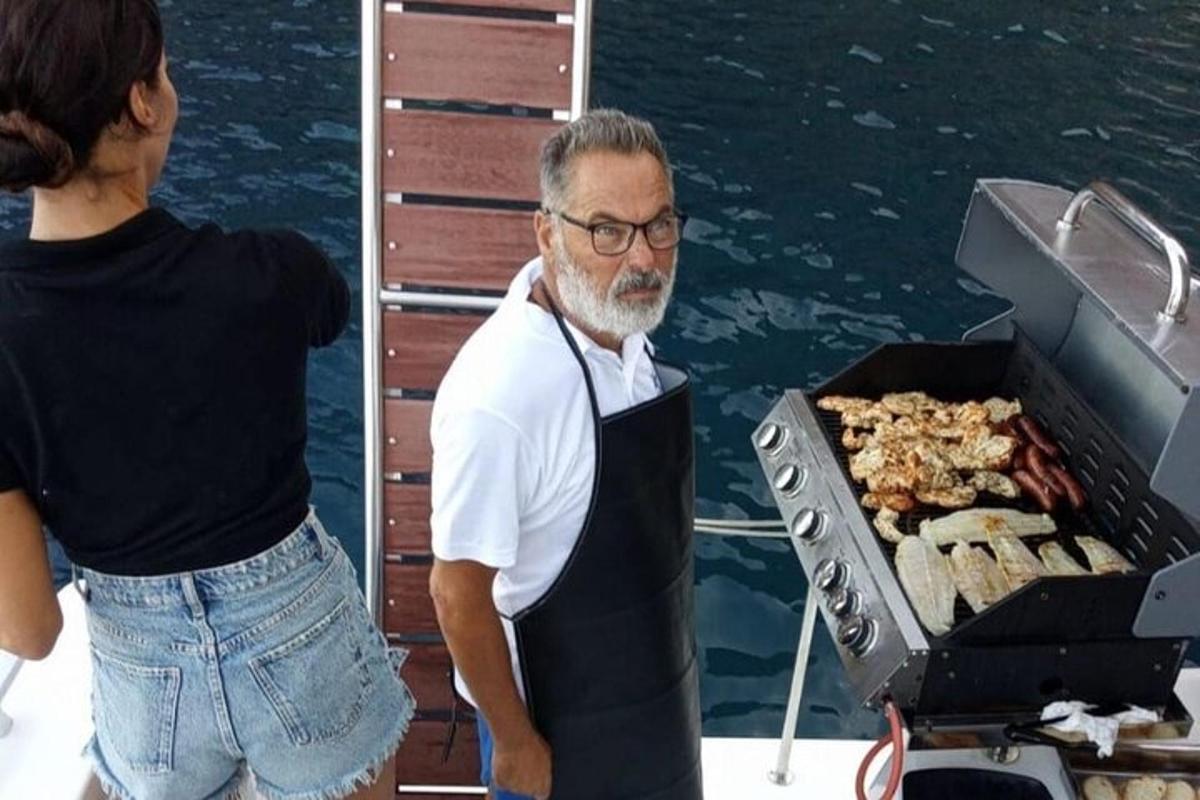 Ένας άντρας που στέκεται σε μια βάρκα δίπλα σε μια ψησταριά