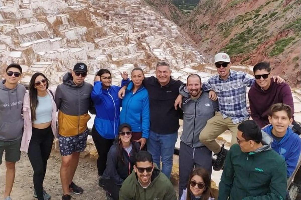 група људи позира за фотографију испред планине