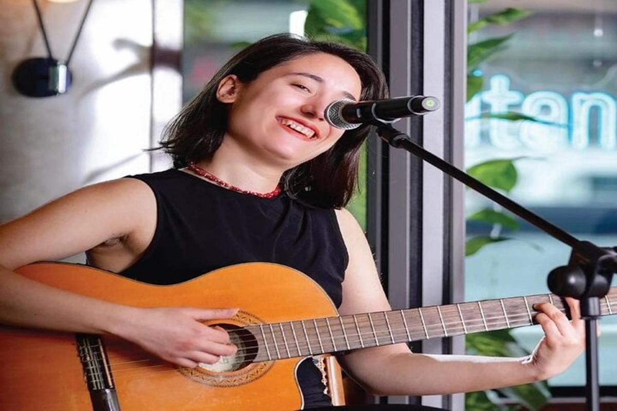 una mujer tocando una guitarra y un micrófono