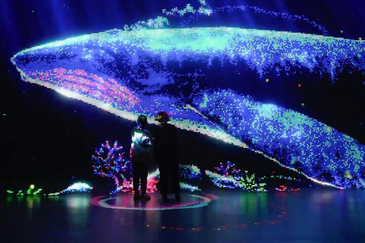 a man and woman standing in front of a light display