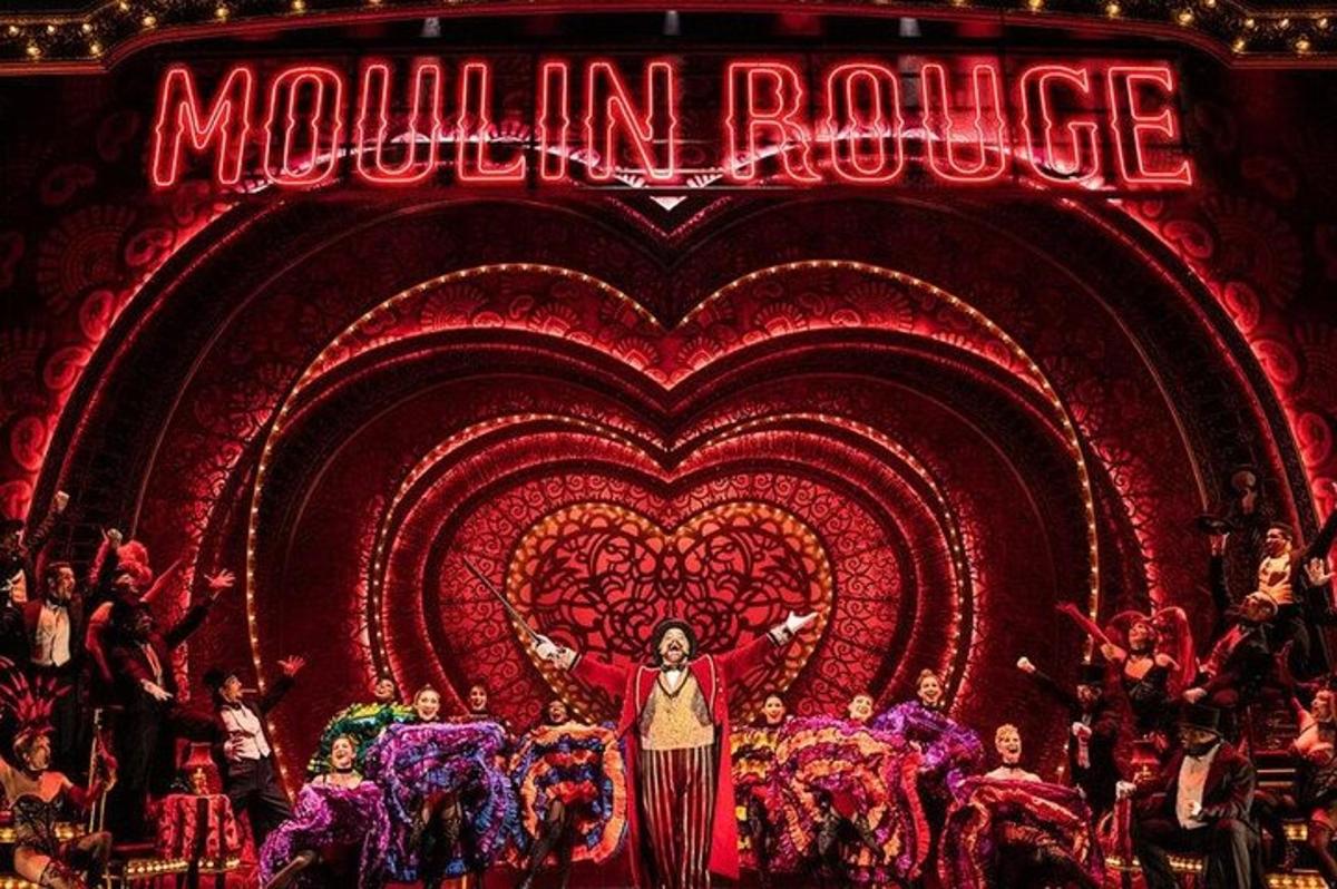 a woman standing on a stage in front of a heart