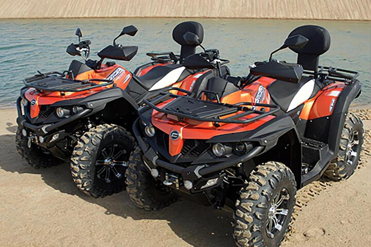 a four wheeler parked on the beach near the water