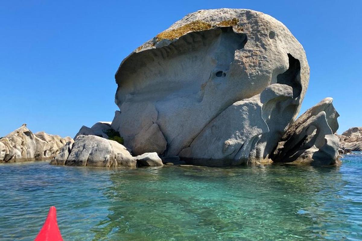 скальное образование в воде с красным конусом
