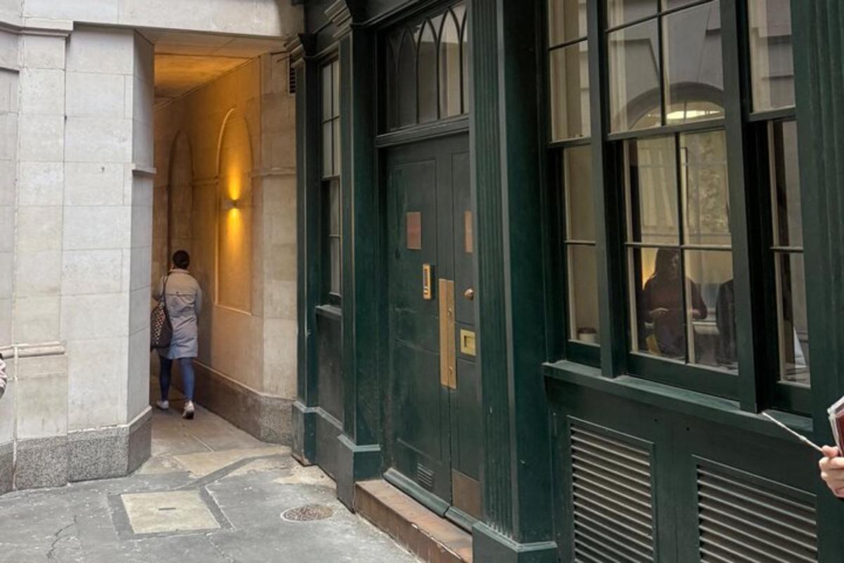 一名男子走在一栋绿色大门建筑的走廊上
