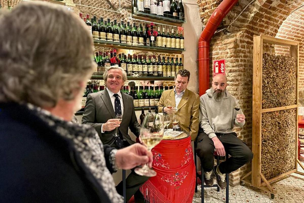 un gruppo di persone sedute al bar con bicchieri di vino