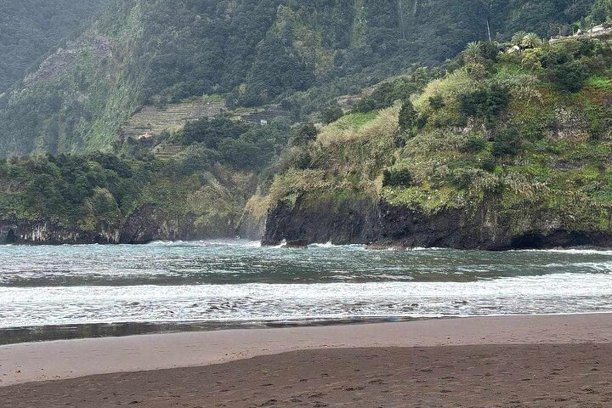 a beach with the ocean and a mountain