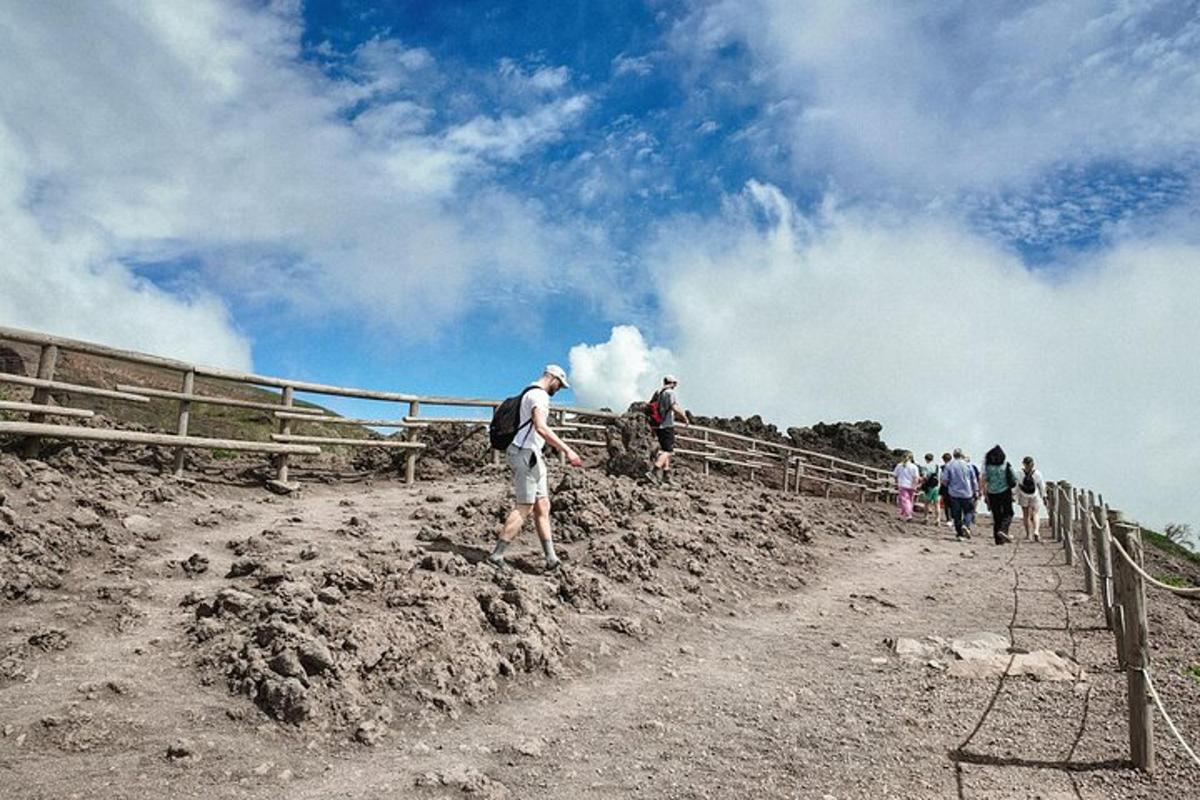 um grupo de pessoas subindo uma colina de terra