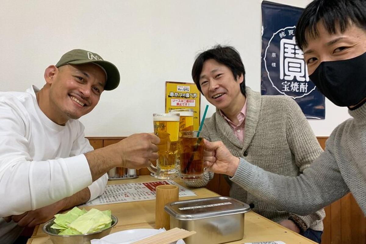um grupo de pessoas sentadas ao redor de uma mesa com uma caneca de cerveja