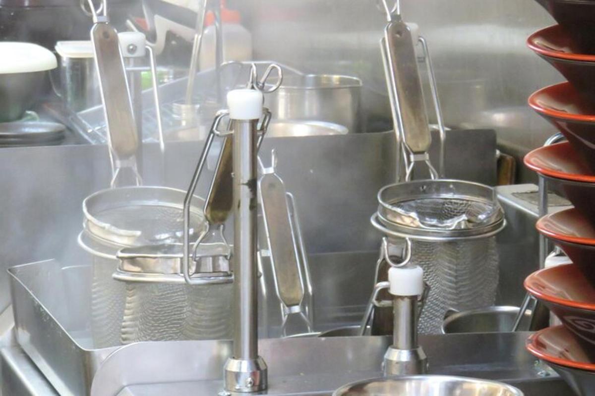 egy konyha edényekkel, serpenyőkkel és mosogatóval