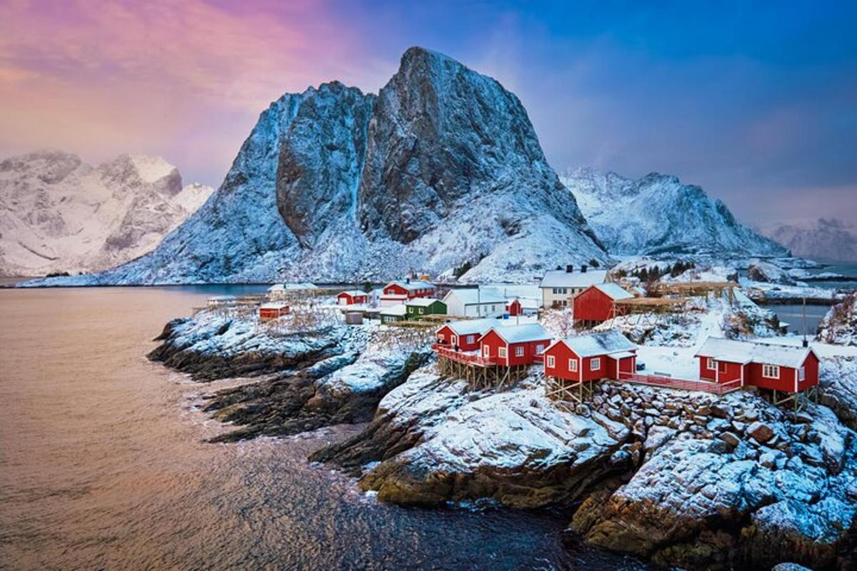 a village on a rocky island with snow covered mountains