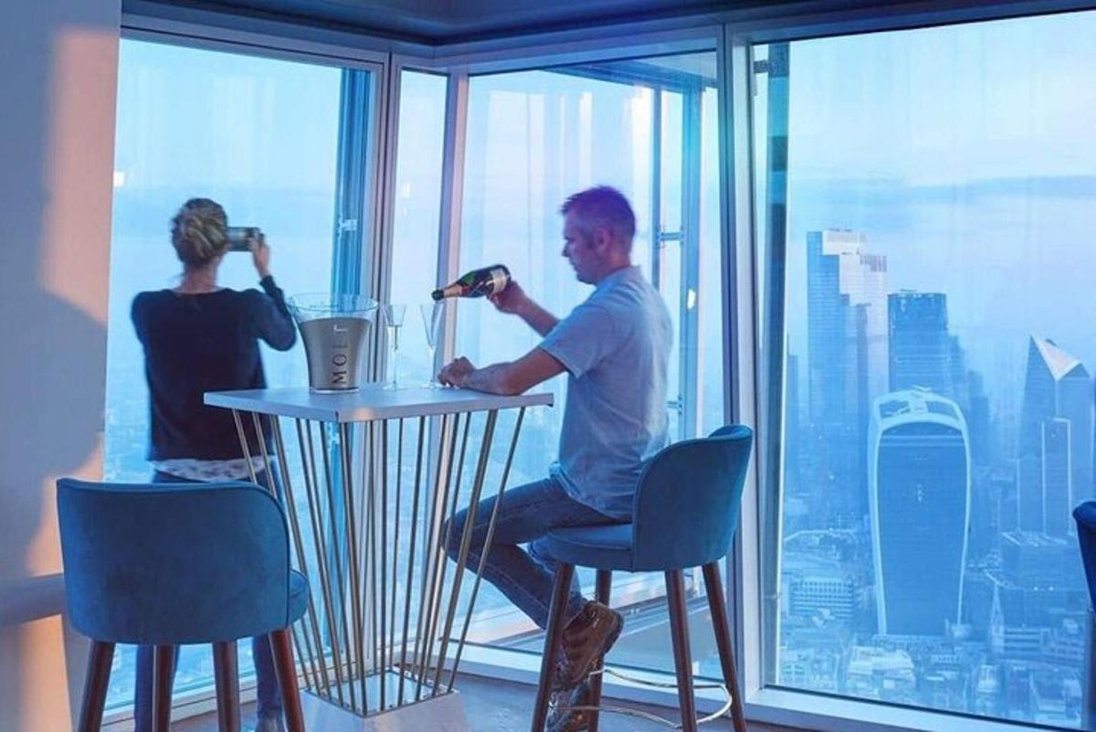 một người đàn ông đang ngồi ở một cái bàn trước cửa sổ