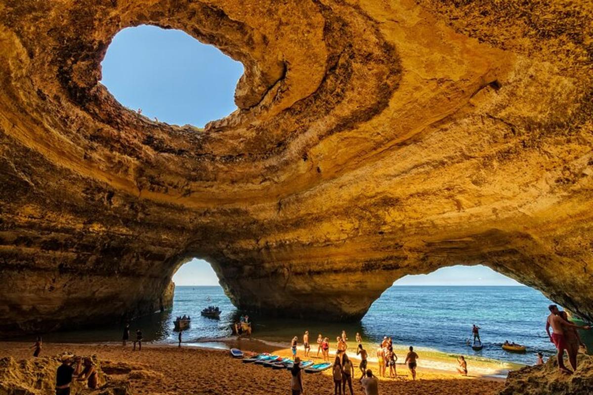 a group of people on a beach in front of a cave