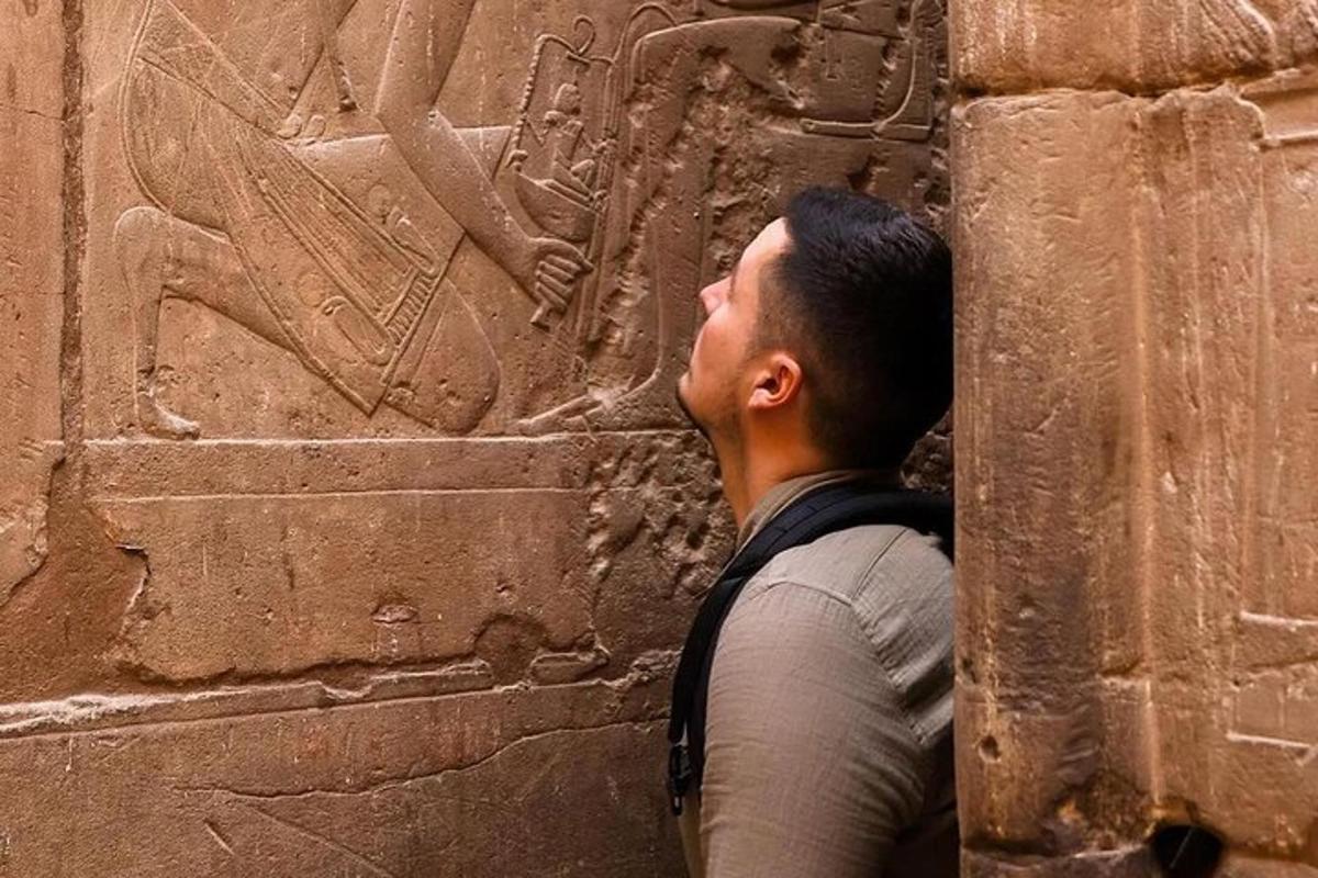 un uomo che guarda un bassorilievo su un muro