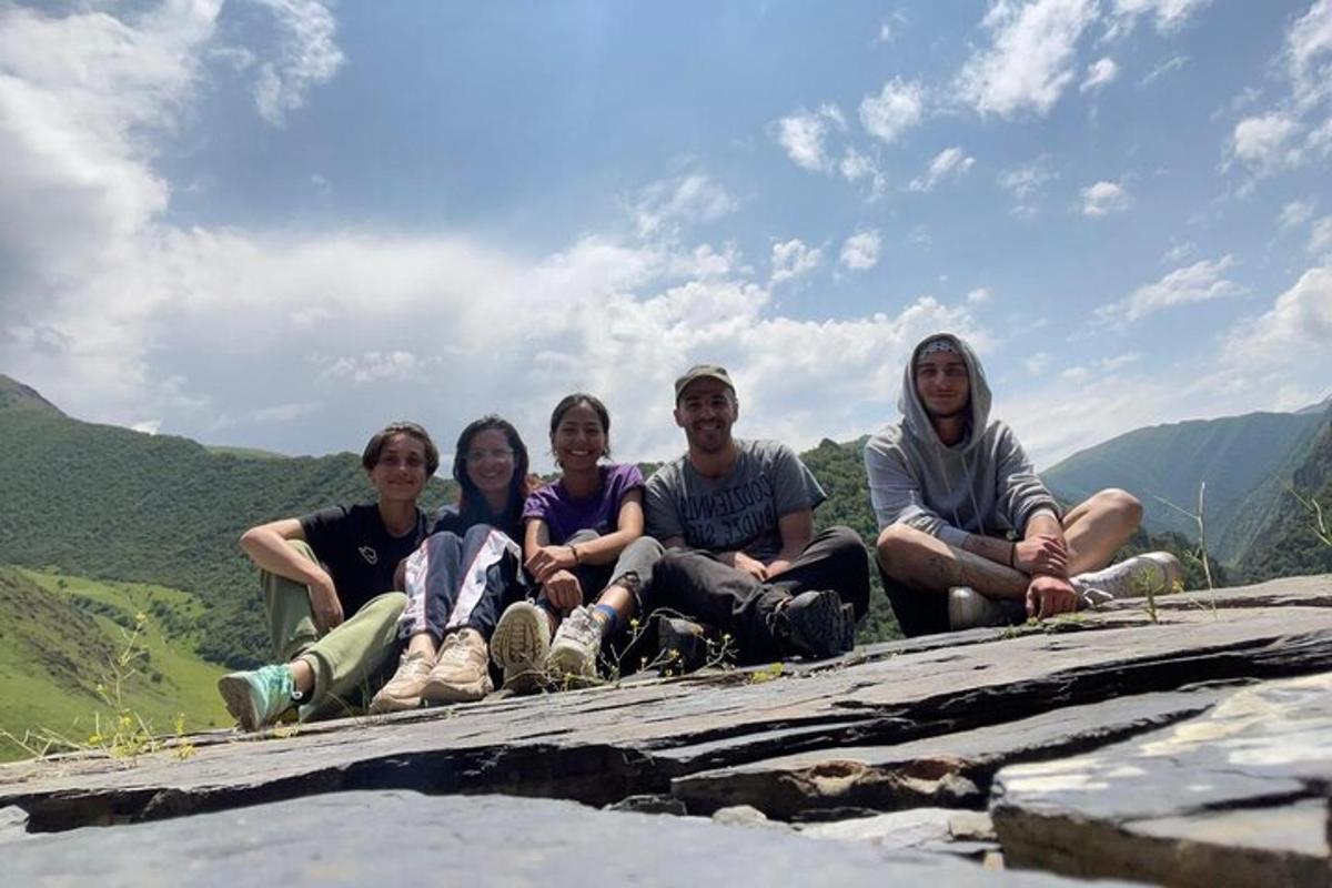 un grup de persones assegudes al cim d'una muntanya