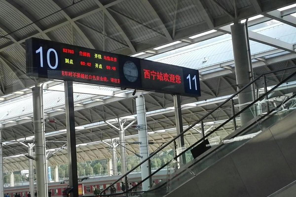 a sign at a train station with a train