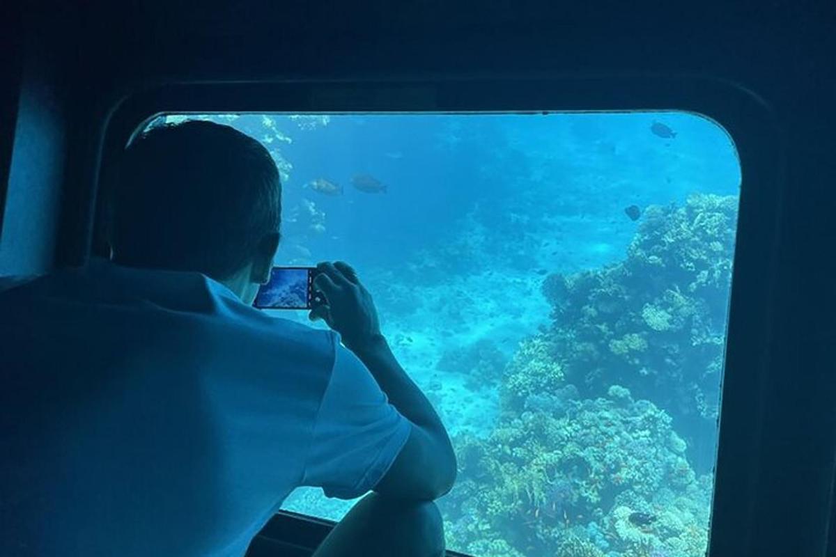 seseorang mengambil gambar laut melalui jendela