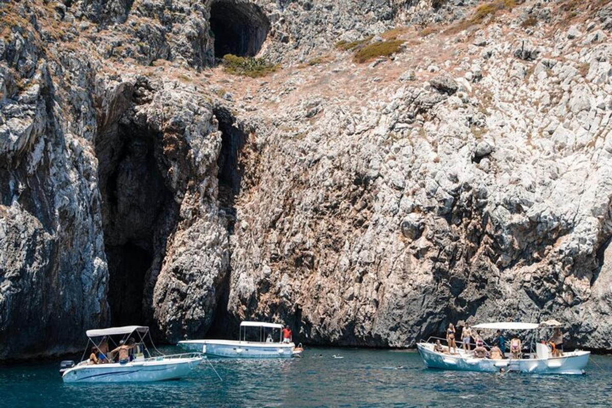 due barche in acqua accanto a una scogliera rocciosa