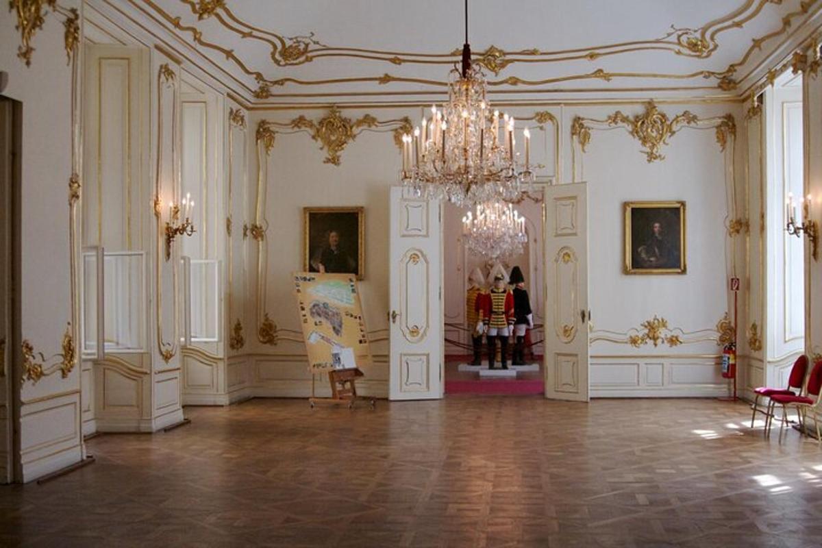 a large room with a chandelier and paintings on the walls