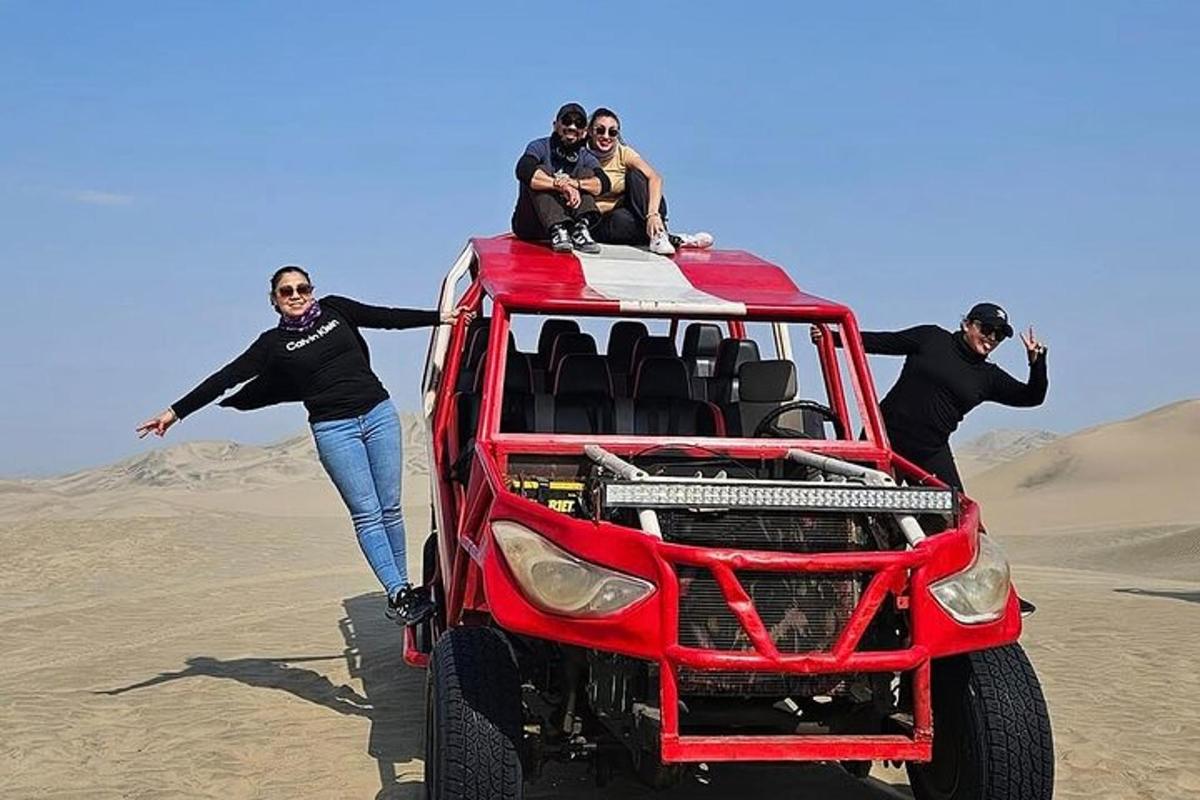 một nhóm người đứng trên nóc một chiếc xe jeep màu đỏ ở sa mạc