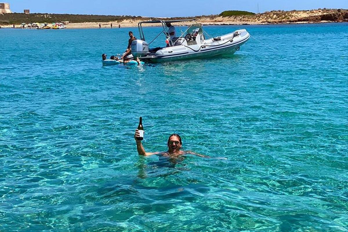 un uomo in acqua con una bottiglia davanti a una barca
