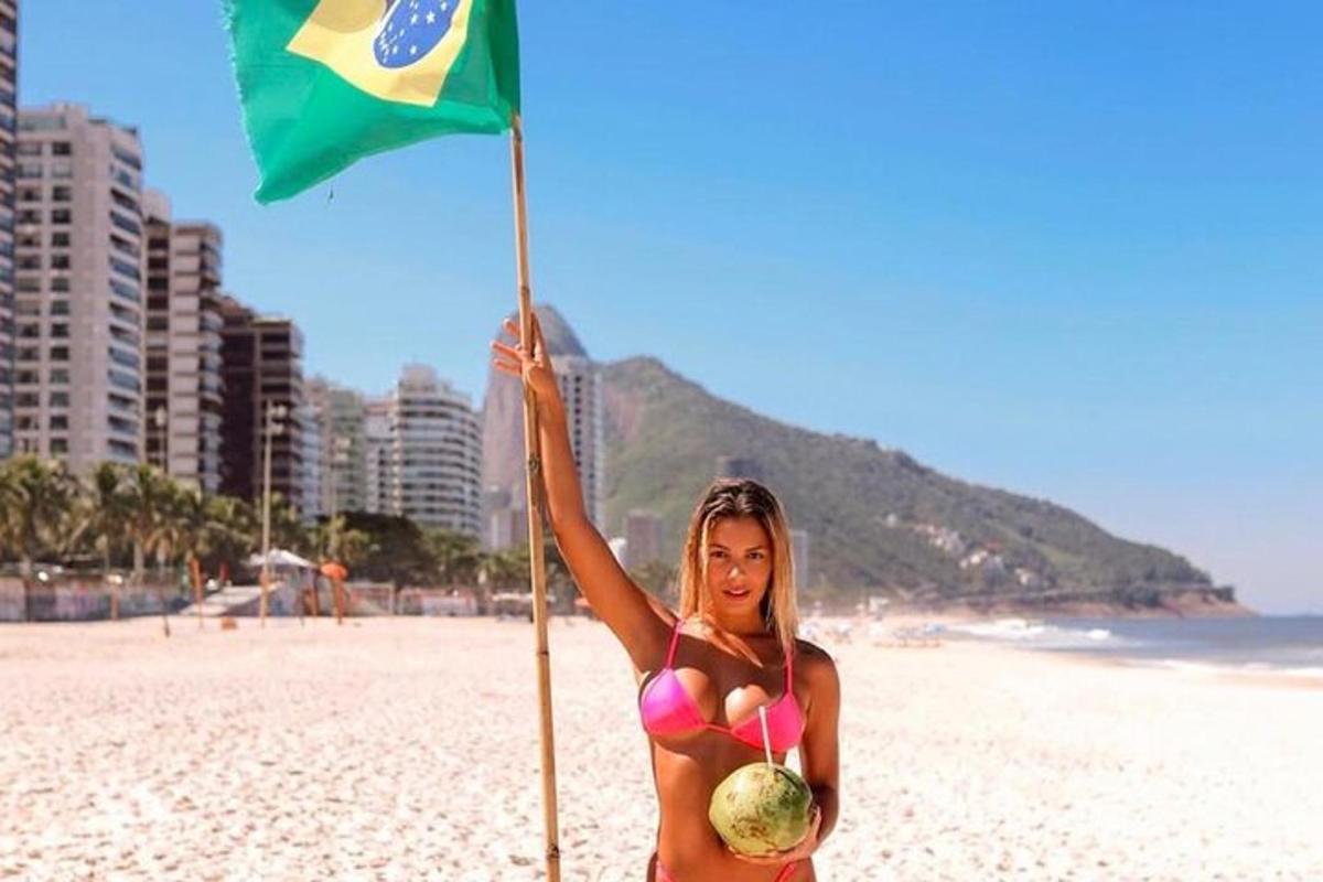 een vrouw in bikini met een vlag op het strand
