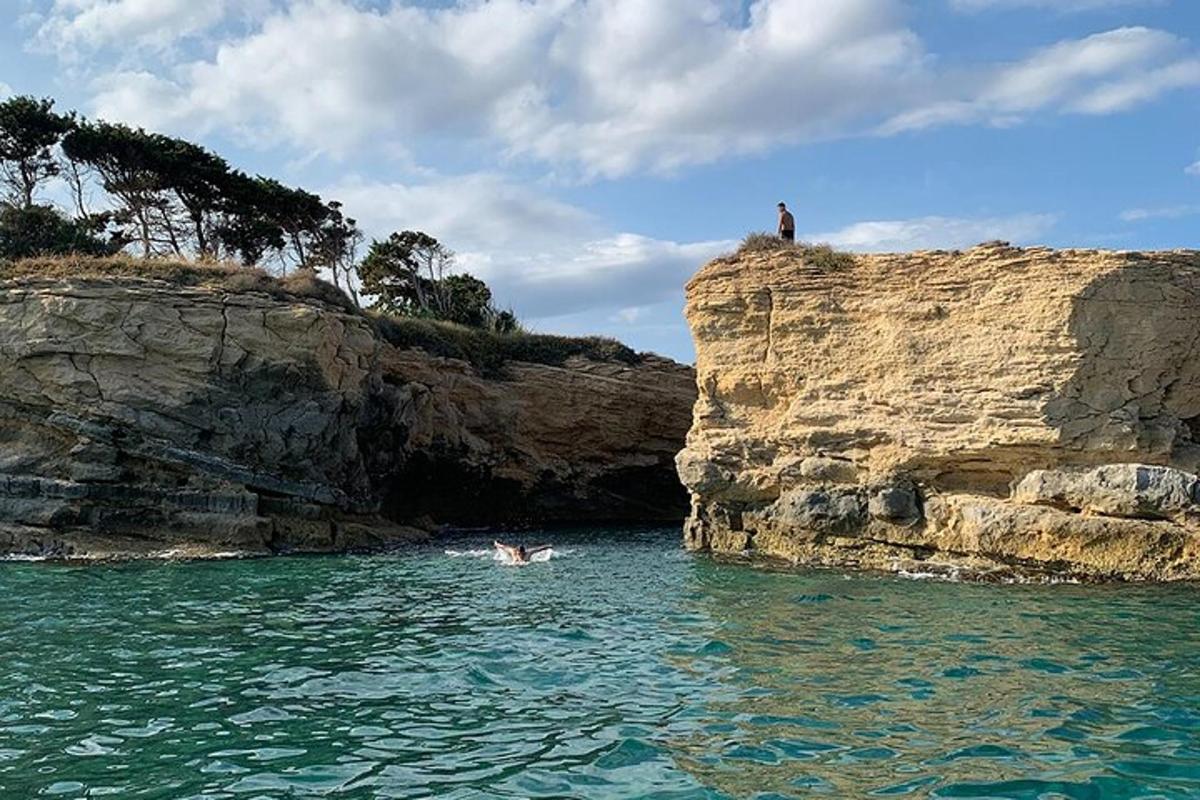 ένα άτομο που κολυμπάει στο νερό κοντά σε έναν απότομο βράχο
