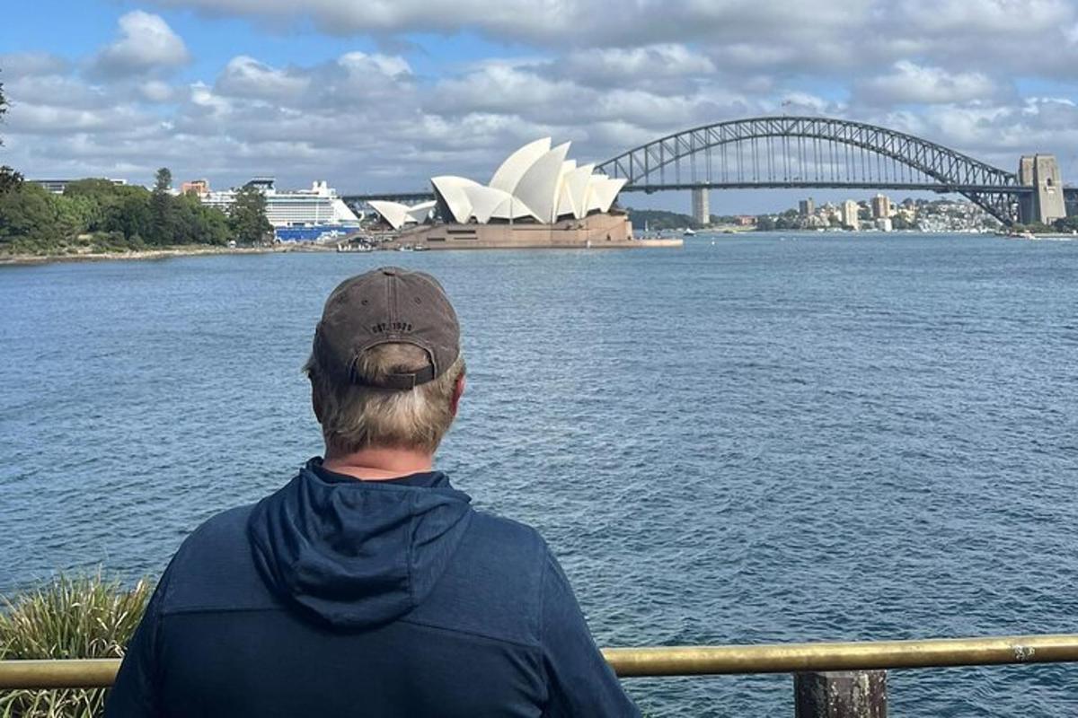 Mees istub käsipuul ja vaatab Sydney ooperimaja