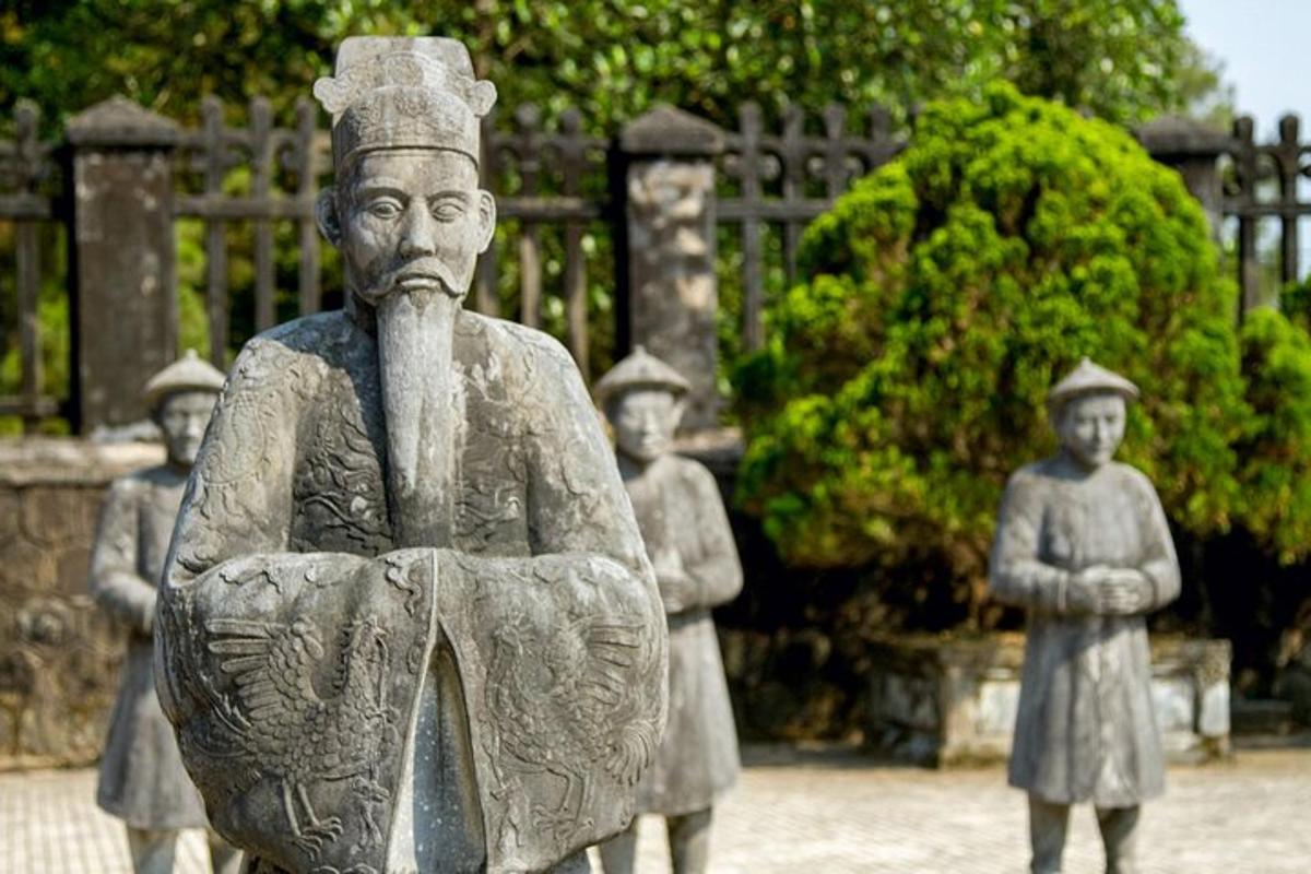 una statua di un uomo con bambini davanti a una recinzione