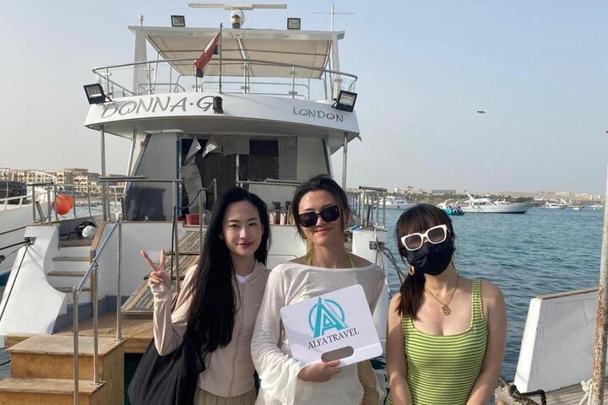tiga wanita berdiri di atas bot dengan tanda