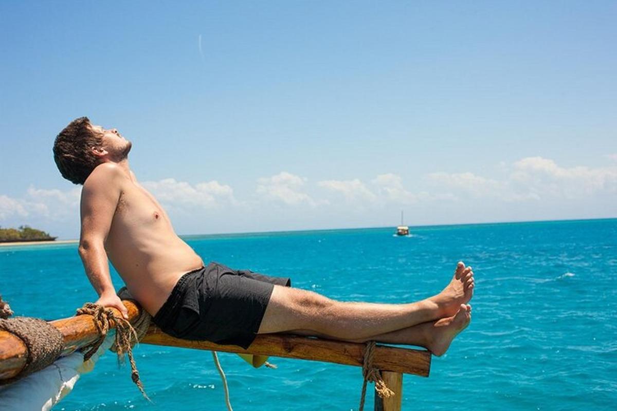muž sedící na molu s výhledem na oceán