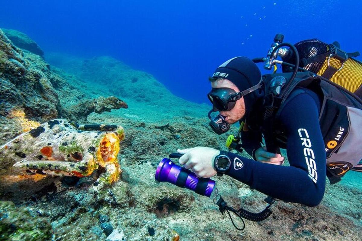 a man taking a picture of a fish on a reef